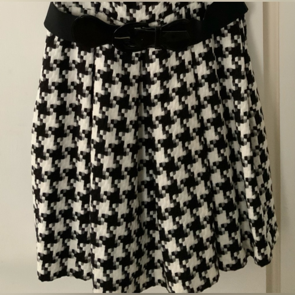 Ladies sleeveless houndstooth pattern dress with black belt. Asymmetrical cut.